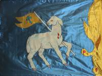 blaue Flagge mit weißem Lamm und goldener Fahne