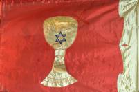 rote Flagge mit goldenem Kelch, darauf ein blauer Davidstern